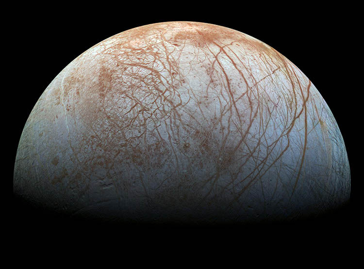 Jupiter's moon Europa. Dark streaks can be seen spreading across the surface like a spider's web.